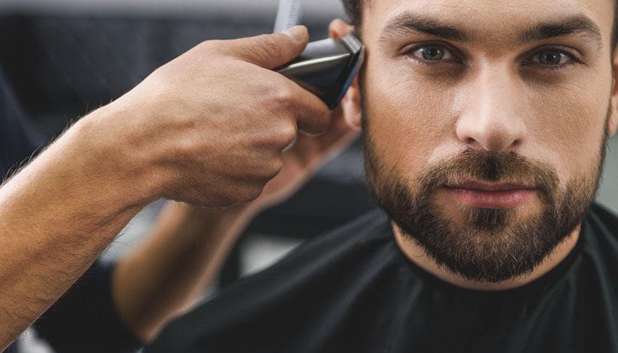 A barber giving a haircut to a customer.